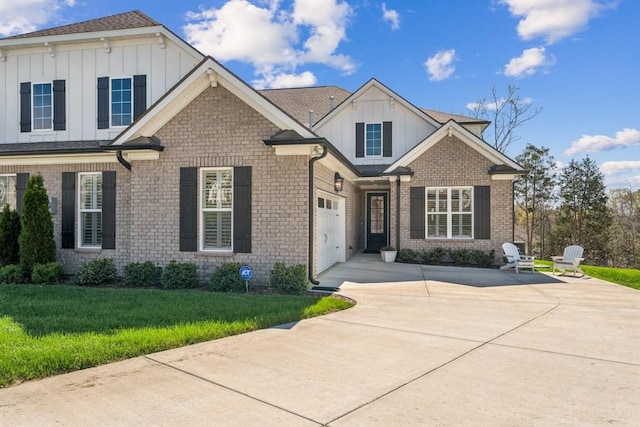 611 Lake Reserve Cv, Hermitage, TN 37076 - view of front of property with board and batten siding, driveway, a front yard, and brick siding