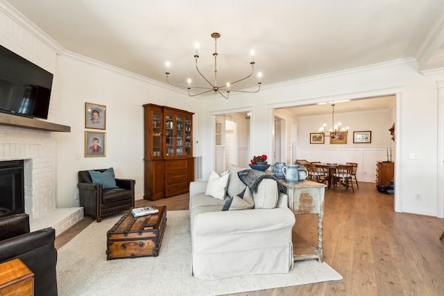 611 Lake Reserve Cv, Hermitage, TN 37076 - living area with a chandelier, ornamental molding, wood finished floors, and a brick fireplace