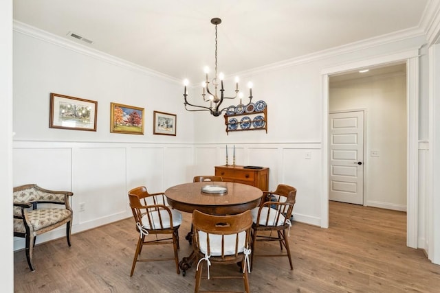 611 Lake Reserve Cv, Hermitage, TN 37076 - dining space featuring a chandelier, crown molding, a decorative wall, light wood finished floors, and a wainscoted wall