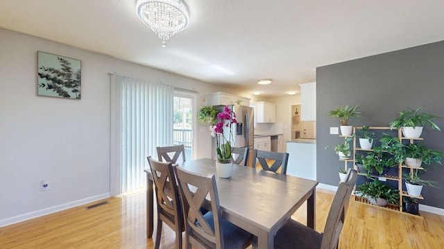 1807 Mosley Ferry Rd, Chapmansboro, TN 37035 - dining area featuring light wood-style flooring, a chandelier, and baseboards