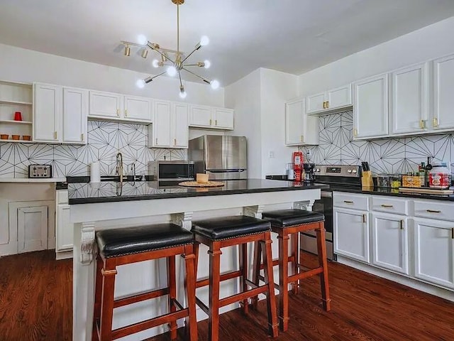 816 Charles Pl, Memphis, TN 38112 - kitchen with stainless steel appliances, backsplash, dark wood finished floors, and a chandelier