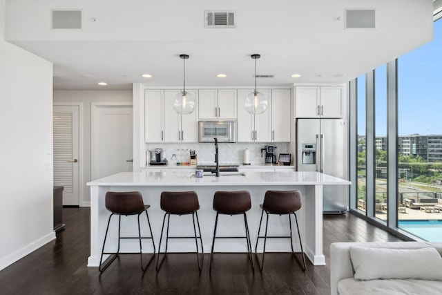 1212 Laurel St Unit 615, Nashville, TN 37203 - kitchen with stainless steel appliances, tasteful backsplash, white cabinets, recessed lighting, and a breakfast bar