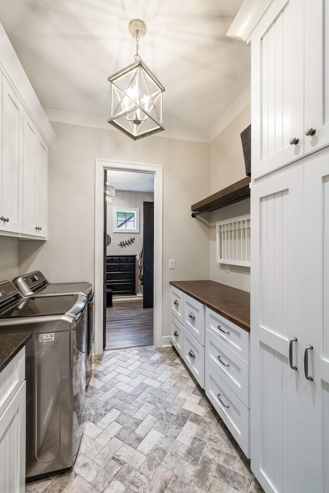 3166 Tanyard Hollow Rd, Culleoka, TN 38451 - laundry area featuring separate washer and dryer, cabinet space, crown molding, a chandelier, and brick flooring