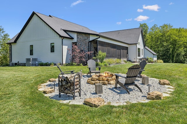 3166 Tanyard Hollow Rd, Culleoka, TN 38451 - back of house with a fire pit, a sunroom, central air condition unit, a lawn, and board and batten siding