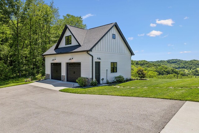 3166 Tanyard Hollow Rd, Culleoka, TN 38451 - view of home's exterior featuring board and batten siding, a yard, a shingled roof, and stone siding