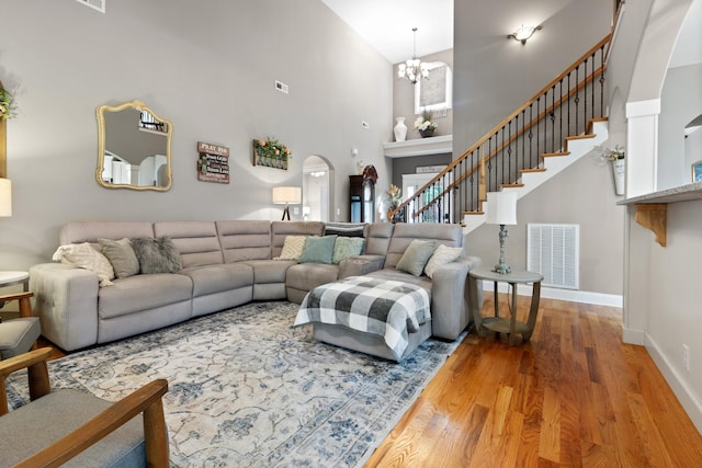 6288 Blacksmith Dr, Pleasant View, TN 37146 - living area with arched walkways, wood finished floors, a high ceiling, baseboards, and a chandelier