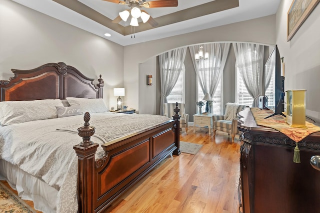 6288 Blacksmith Dr, Pleasant View, TN 37146 - bedroom featuring light wood-style floors, a tray ceiling, recessed lighting, arched walkways, and a ceiling fan