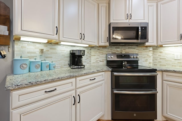 6288 Blacksmith Dr, Pleasant View, TN 37146 - kitchen with appliances with stainless steel finishes, tasteful backsplash, light stone countertops, and white cabinets