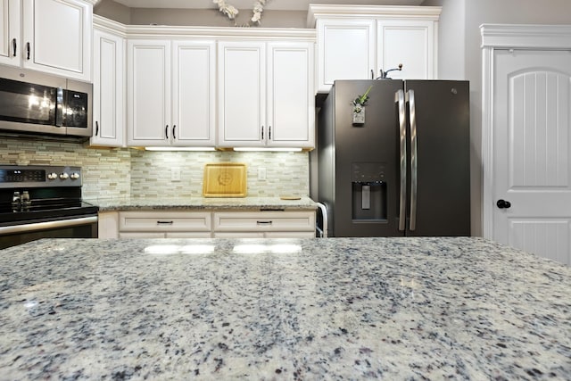 6288 Blacksmith Dr, Pleasant View, TN 37146 - kitchen with appliances with stainless steel finishes, light stone counters, decorative backsplash, and white cabinetry
