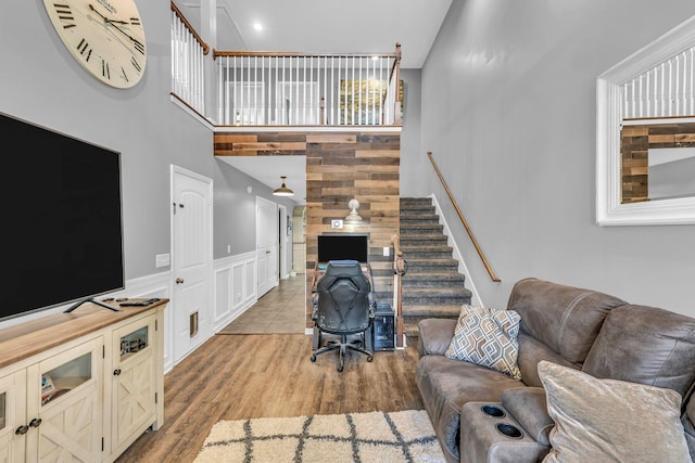 911 Keepsake Diamond Ln, Murfreesboro, TN 37128 - living room with stairway, wood finished floors, wainscoting, a towering ceiling, and a decorative wall