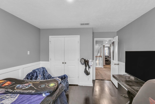 911 Keepsake Diamond Ln, Murfreesboro, TN 37128 - bedroom with a closet, a wainscoted wall, wood finished floors, and a textured ceiling