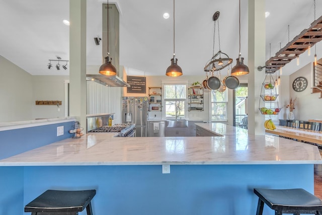 6416 Edsel Dr, Nashville, TN 37209 - kitchen with appliances with stainless steel finishes, a sink, light stone counters, a kitchen bar, and a peninsula