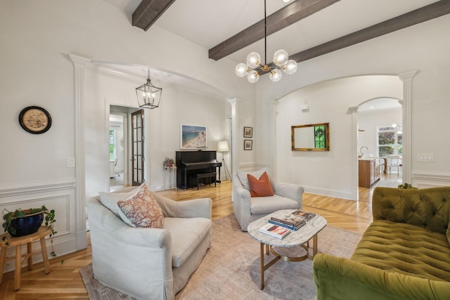 4083 Kings Camp Pass, Arrington, TN 37014 - living area with arched walkways, a chandelier, beam ceiling, light wood-style floors, and decorative columns