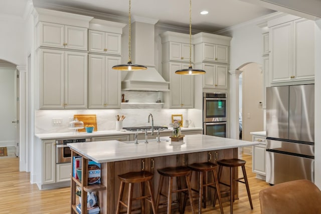4083 Kings Camp Pass, Arrington, TN 37014 - kitchen featuring stainless steel appliances, open shelves, arched walkways, light wood-style floors, and ornamental molding