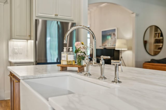 4083 Kings Camp Pass, Arrington, TN 37014 - kitchen view of a sink, arched walkways, light stone countertops, and freestanding refrigerator