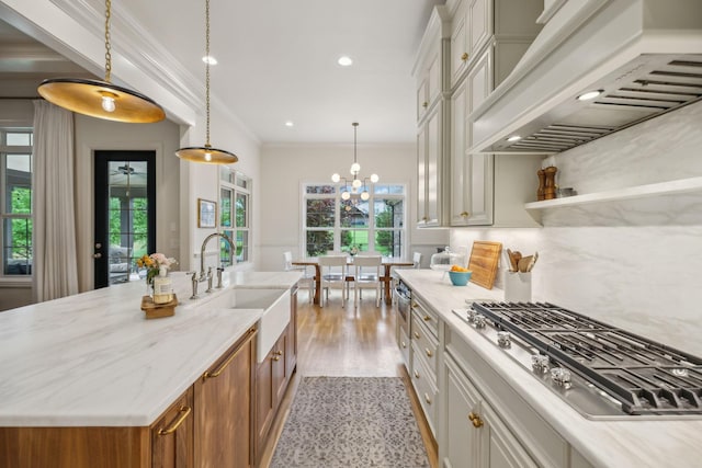 4083 Kings Camp Pass, Arrington, TN 37014 - kitchen with premium range hood, stainless steel gas cooktop, a sink, brown cabinetry, and light wood-type flooring