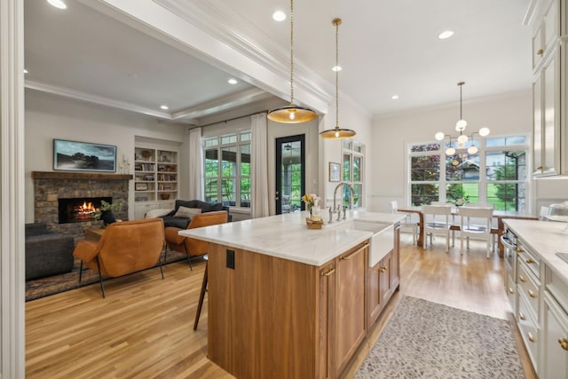 4083 Kings Camp Pass, Arrington, TN 37014 - kitchen featuring ornamental molding, light wood finished floors, a sink, a fireplace, and an island with sink