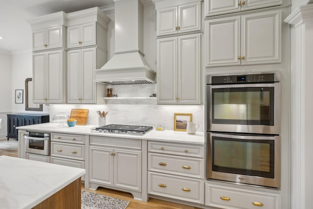 4083 Kings Camp Pass, Arrington, TN 37014 - kitchen featuring stainless steel appliances, custom range hood, light stone counters, backsplash, and white cabinetry