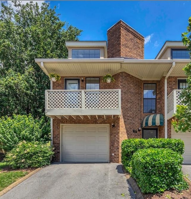 235 Glenstone Cir, Brentwood, TN 37027 - view of front of house with an attached garage, brick siding, asphalt driveway, and a chimney