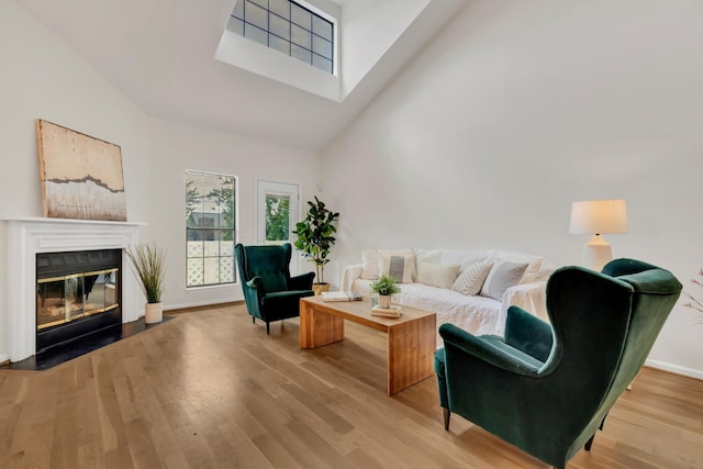 235 Glenstone Cir, Brentwood, TN 37027 - living area with a high ceiling, wood finished floors, a fireplace with flush hearth, a skylight, and baseboards