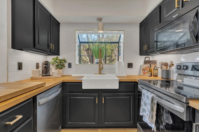 235 Glenstone Cir, Brentwood, TN 37027 - kitchen with appliances with stainless steel finishes, wooden counters, a sink, decorative backsplash, and dark cabinets