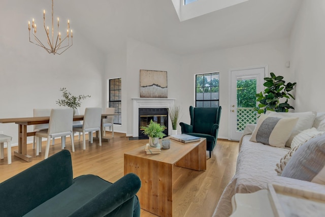 235 Glenstone Cir, Brentwood, TN 37027 - living room featuring a chandelier, a glass covered fireplace, light wood-type flooring, and a skylight