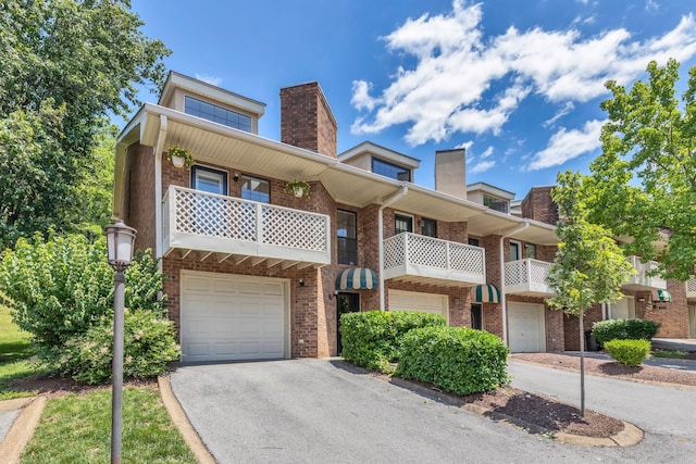 235 Glenstone Cir, Brentwood, TN 37027 - townhome / multi-family property featuring an attached garage, brick siding, asphalt driveway, a chimney, and a balcony