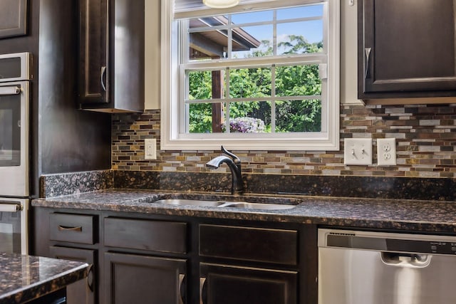 3296 Wiser Dr, Clarksville, TN 37042 - kitchen featuring appliances with stainless steel finishes, dark brown cabinetry, backsplash, and dark stone counters