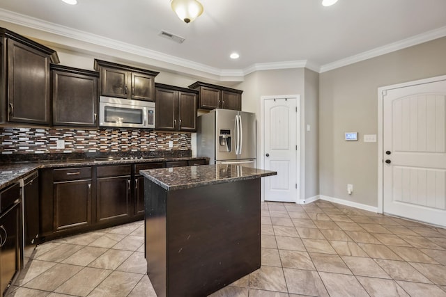 3296 Wiser Dr, Clarksville, TN 37042 - kitchen with appliances with stainless steel finishes, a center island, crown molding, dark brown cabinets, and decorative backsplash