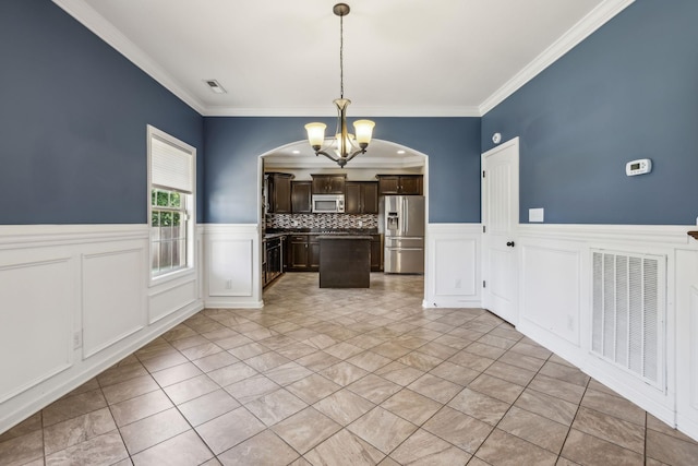 3296 Wiser Dr, Clarksville, TN 37042 - kitchen with stainless steel appliances, a chandelier, dark brown cabinetry, a wainscoted wall, and ornamental molding
