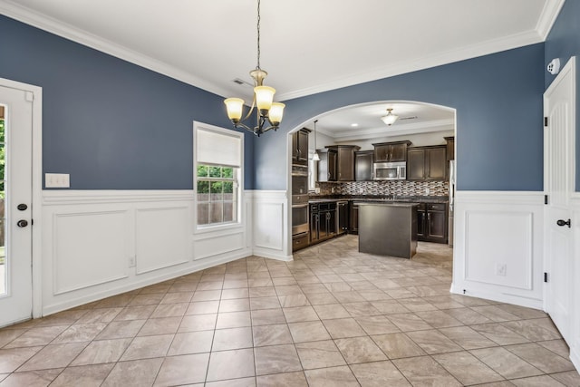 3296 Wiser Dr, Clarksville, TN 37042 - kitchen with stainless steel appliances, dark brown cabinetry, ornamental molding, a chandelier, and a kitchen island