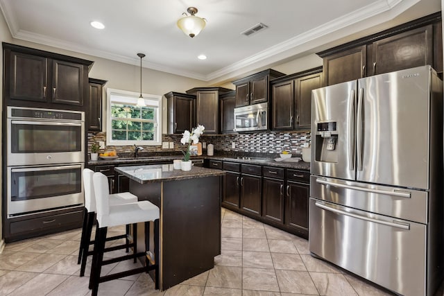 3296 Wiser Dr, Clarksville, TN 37042 - kitchen with appliances with stainless steel finishes, a center island, dark brown cabinets, dark stone countertops, and tasteful backsplash