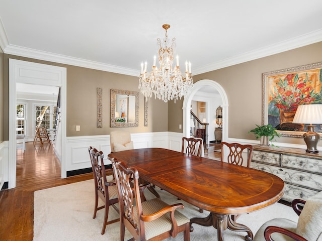 504 Chippenham Ct, Franklin, TN 37069 - dining space with arched walkways, crown molding, a chandelier, wood finished floors, and a wainscoted wall