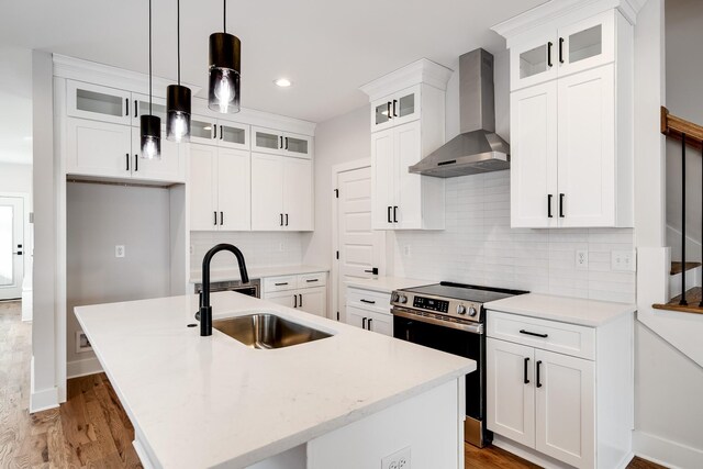 2120 Burns St, Nashville, TN 37216 - kitchen with wall chimney exhaust hood, stainless steel range with electric cooktop, a center island with sink, wood finished floors, and recessed lighting