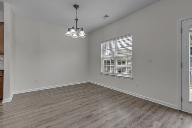 1039 Hemlock Dr, Spring Hill, TN 37174 - unfurnished dining area featuring wood finished floors, a chandelier, and baseboards