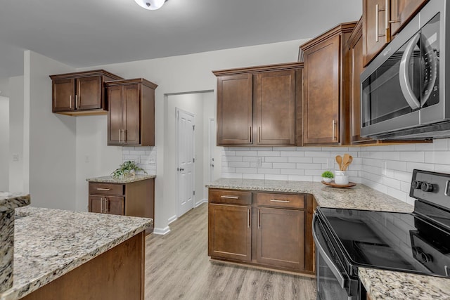 1039 Hemlock Dr, Spring Hill, TN 37174 - kitchen with appliances with stainless steel finishes, light stone countertops, and light wood-style floors