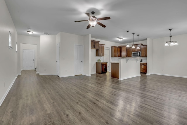 1039 Hemlock Dr, Spring Hill, TN 37174 - unfurnished living room featuring dark wood-type flooring, a ceiling fan, baseboards, and a chandelier