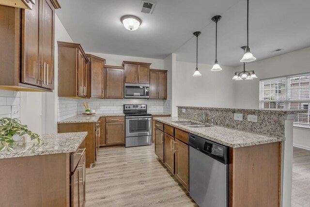 1039 Hemlock Dr, Spring Hill, TN 37174 - kitchen featuring stainless steel appliances, a sink, light wood-style floors, and backsplash