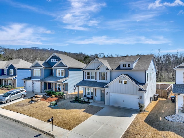 8792 Snowy Owl Rd, Ooltewah, TN 37363 - view of front facade featuring board and batten siding, driveway, a garage, covered porch, and a residential view