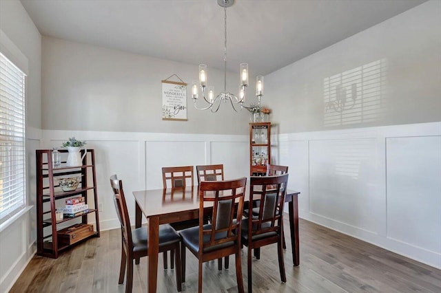 8792 Snowy Owl Rd, Ooltewah, TN 37363 - dining room with a decorative wall, wood finished floors, a chandelier, and a wainscoted wall