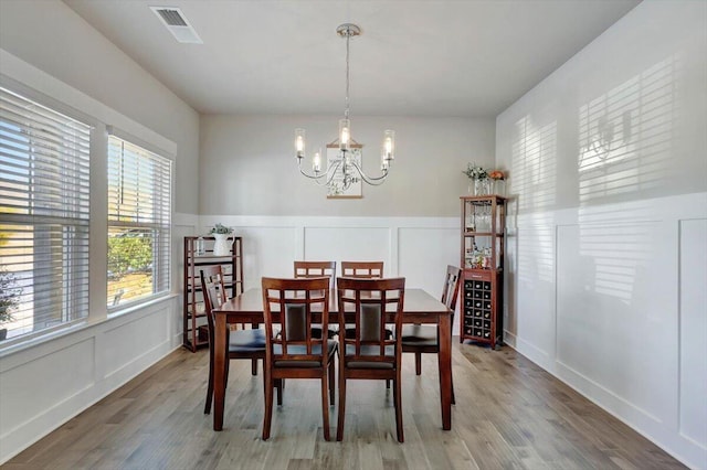 8792 Snowy Owl Rd, Ooltewah, TN 37363 - dining room featuring a decorative wall, light wood-type flooring, a chandelier, and wainscoting