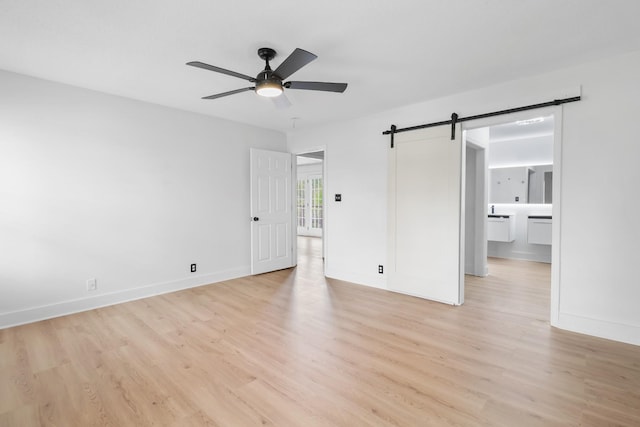 925 Tommy Oliver Rd, Clarksville, TN 37042 - unfurnished bedroom with a barn door, light wood-type flooring, ensuite bathroom, and ceiling fan