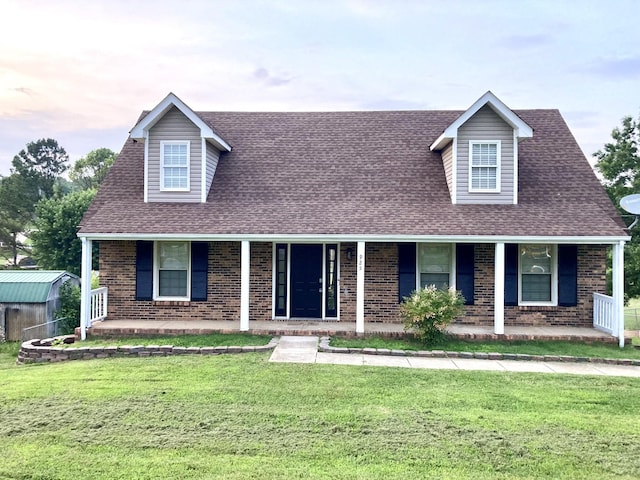 925 Tommy Oliver Rd, Clarksville, TN 37042 - cape cod home with a porch, brick siding, a front lawn, and a shingled roof