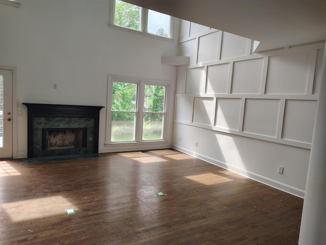 1202 Willow Brook Pass, Mount Juliet, TN 37122 - unfurnished living room featuring wood finished floors, healthy amount of natural light, baseboards, a fireplace, and a towering ceiling