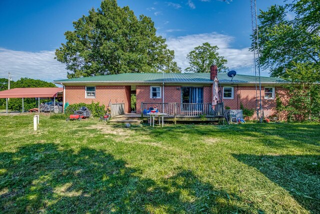 135 Old Union Church Rd, Holladay, TN 38341 - back of property featuring brick siding, a deck, a detached carport, and a yard