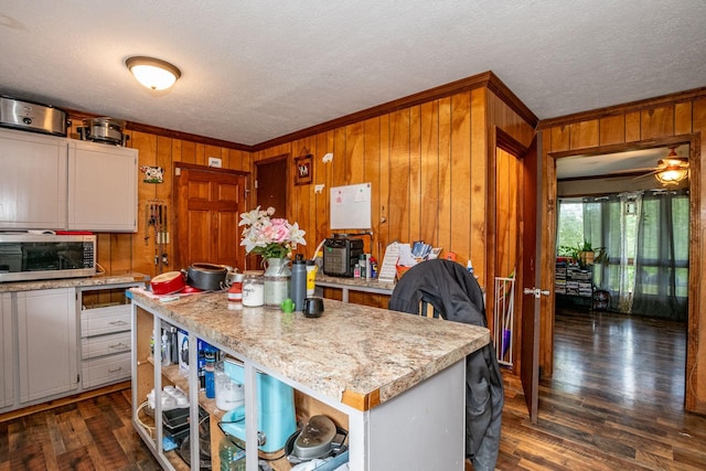 135 Old Union Church Rd, Holladay, TN 38341 - kitchen featuring stainless steel microwave, ornamental molding, wood walls, dark wood-style flooring, and open shelves