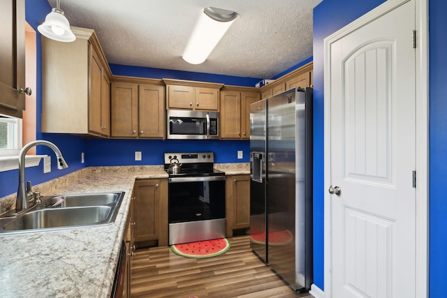 1217 Merritt Hill Trl, Smyrna, TN 37167 - kitchen with appliances with stainless steel finishes, a sink, wood finished floors, light countertops, and brown cabinets