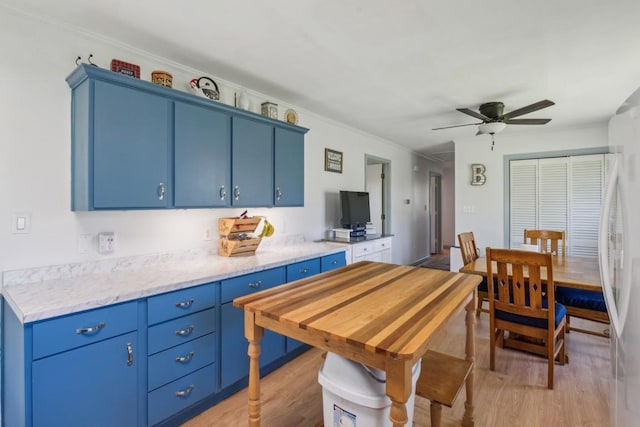 1190 Corum Hill Rd, Castalian Springs, TN 37031 - kitchen with blue cabinets, light wood-style flooring, ceiling fan, refrigerator, and crown molding