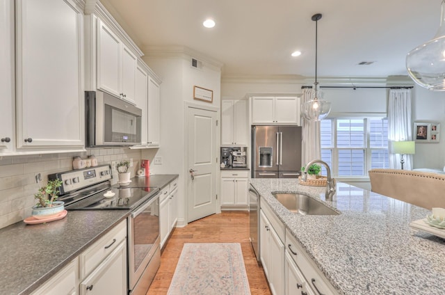 3433 Cortona Way, Murfreesboro, TN 37129 - kitchen featuring appliances with stainless steel finishes, a sink, light wood-type flooring, white cabinets, and decorative backsplash