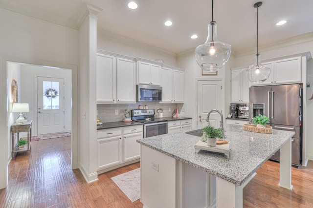 3433 Cortona Way, Murfreesboro, TN 37129 - kitchen featuring appliances with stainless steel finishes, a sink, ornamental molding, white cabinetry, and a kitchen island with sink